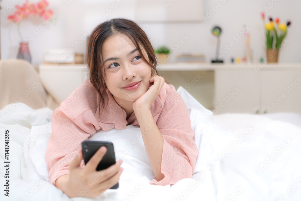Asian young woman relaxing before bedtime on the bed in the bedroom Asian young woman relaxing before bedtime on the bed in the bedroom