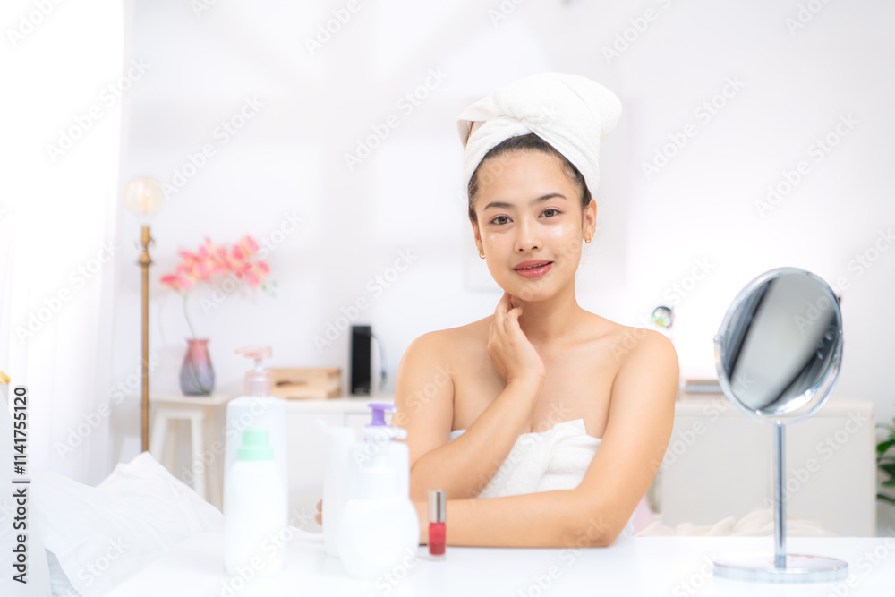 Asian young woman with towel wrapped on head and body applying makeup after shower, Morning beauty routine before work Asian young woman with towel wrapped on head and body applying makeup after shower, Morning beauty routine before work