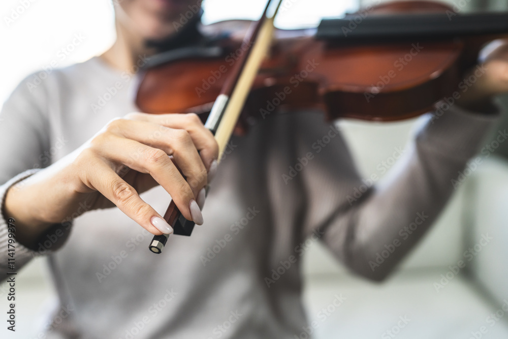 close up of unknown woman playing violin at home close up of unknown woman playing violin at home