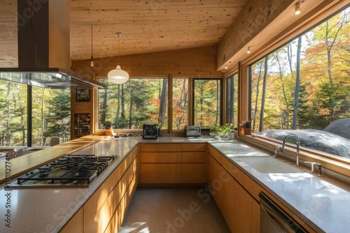 Modern kitchen with large windows overlooking autumn forest in a peaceful setting
