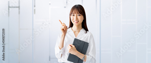 タブレットを持って案内をする笑顔の女性・ビジネスウーマン