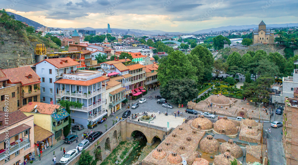 Aerial view of Tbilisi Old town with traditional wooden balconies and bathhouses with panoramic view of the city in the background