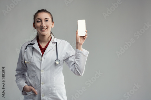 Young female doctor showing smartphone with blank screen photo