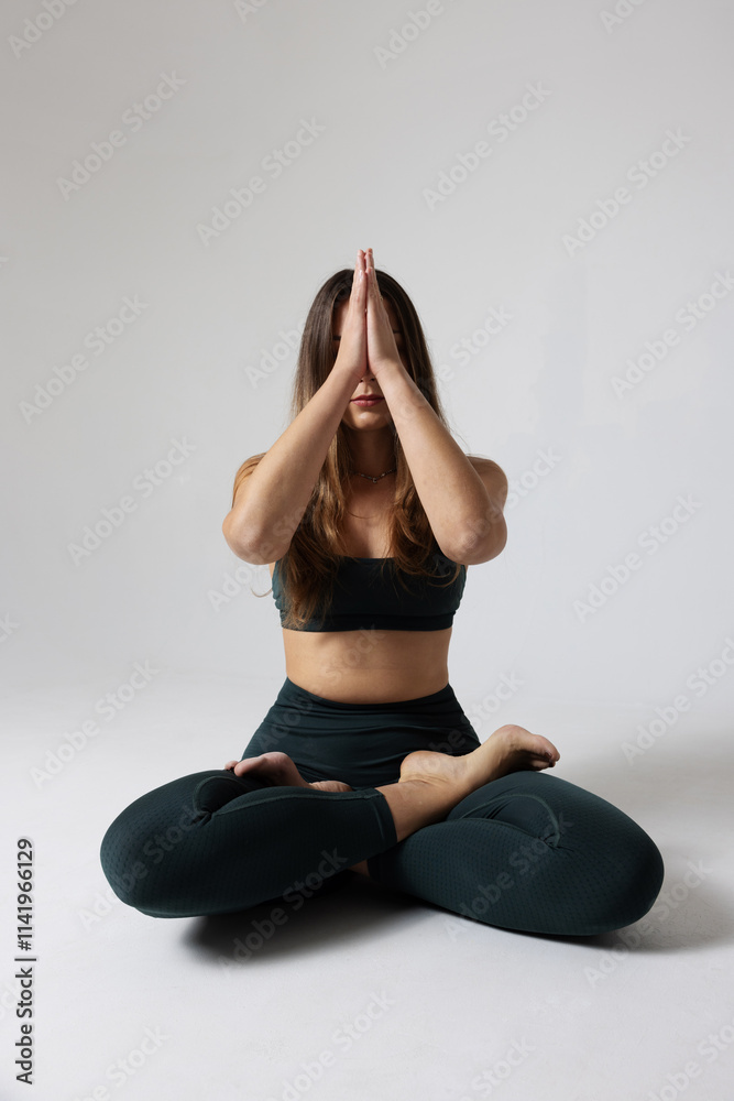 Fototapeta premium Headshot of sporty young woman doing exercise in studio practicing yoga. 