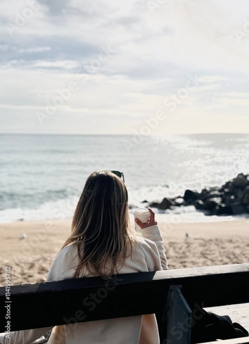 Photography Woman Sitting on a Bench Facing the Sea, Drinking Coffee on a Sunny Day