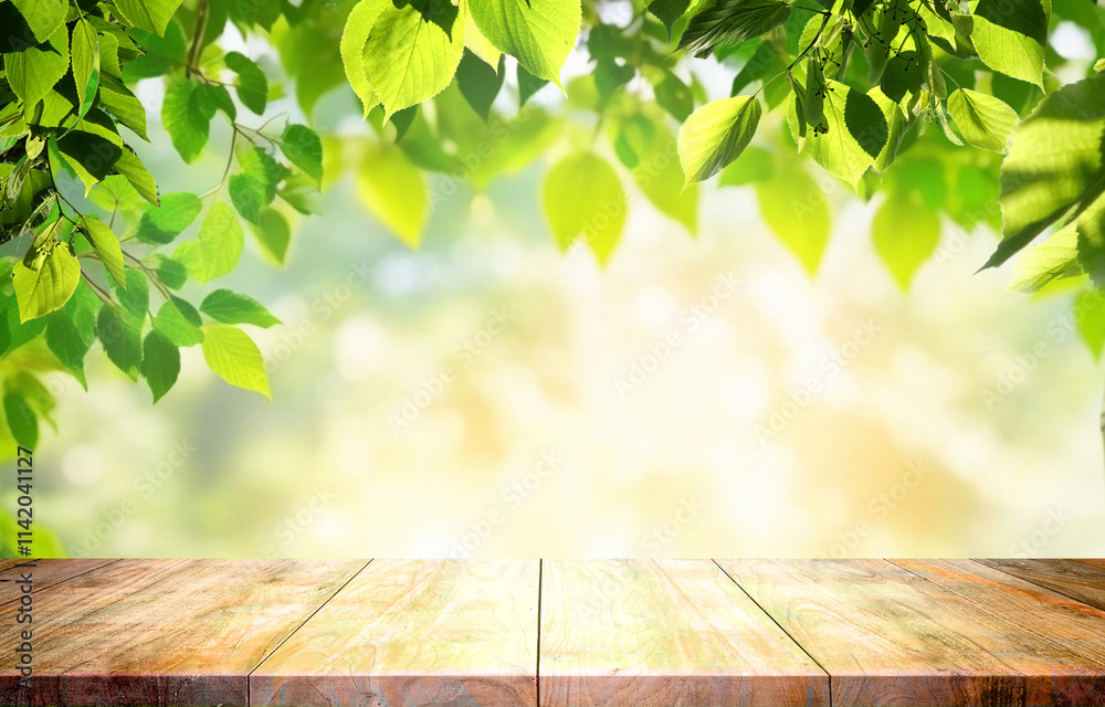 Spring beautiful background with green juicy young foliage and empty wooden table in nature outdoor. Natural template for presentation.