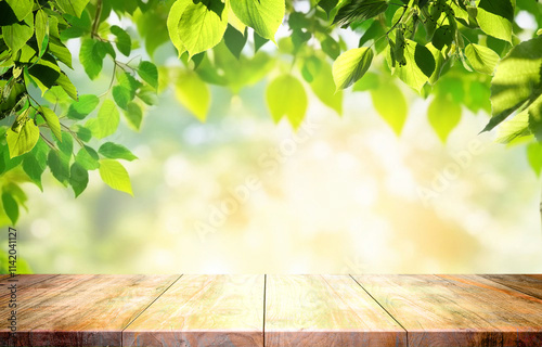Obraz na płótnie Spring beautiful background with green juicy young foliage and empty wooden table in nature outdoor. Natural template for presentation. w salonie