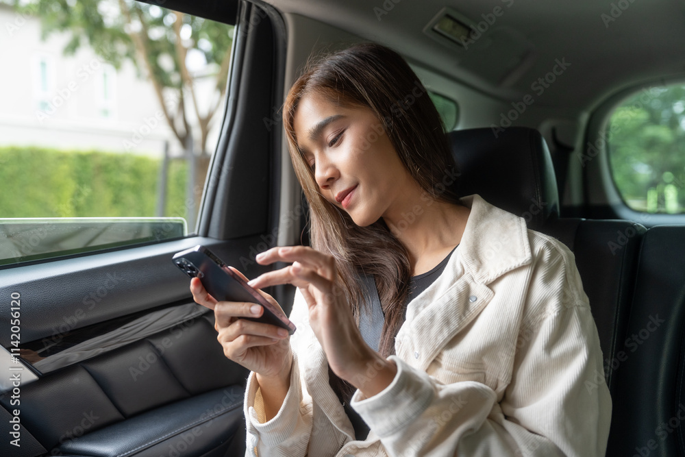 Asian Woman Traveler sitting in car back seats using smartphone call taxi service in application. Online app with cell phone and put on safety belt. Female passenger in car traveling to destination. Asian Woman Traveler sitting in car back seats using smartphone call taxi service in application. Online app with cell phone and put on safety belt. Female passenger in car traveling to destination.
