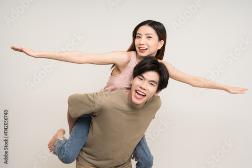 Piggyback ride Happy asian couple attractive in various action gesture standing on isolated white background. Cheerful Smiling young man and woman fun with piggyback ride photo