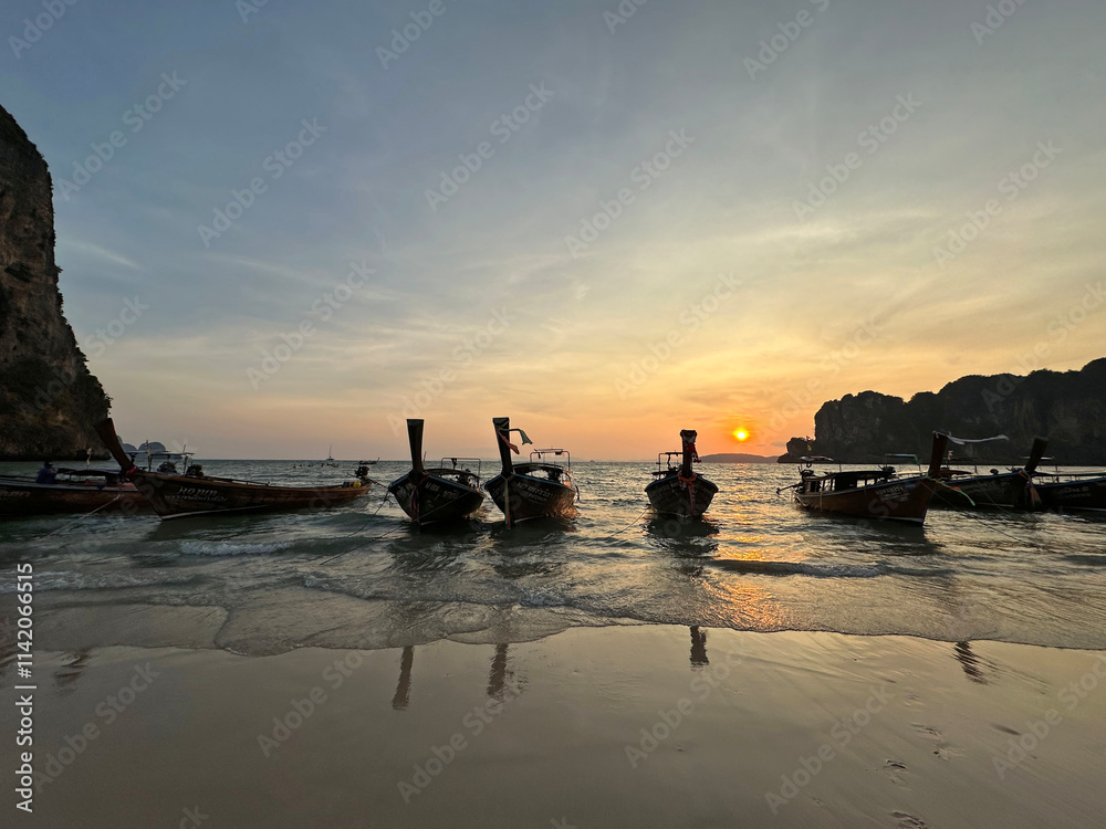A collection of boats can be seen docked peacefully in the water at sunset A collection of boats can be seen docked peacefully in the water at sunset