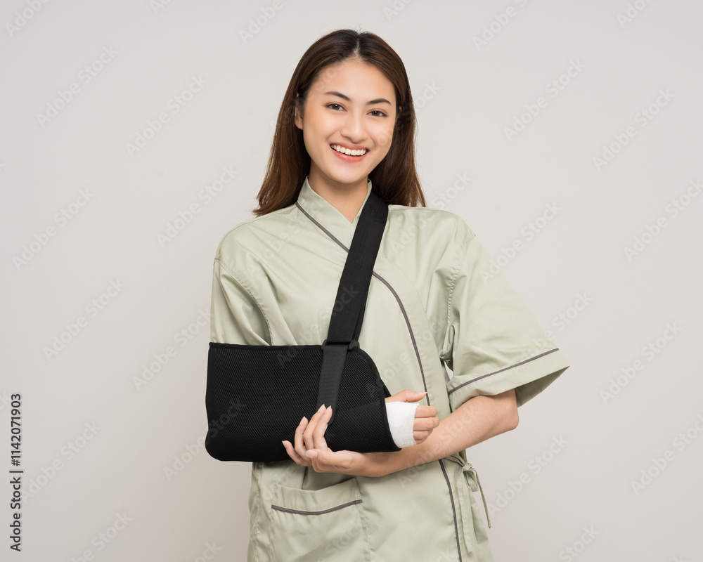 Happy young asian woman broken arm on isolated background. Asian female put on plaster bandage cast splint. Patient wearing sling support arm after accident injury. life insurance and accident Happy young asian woman broken arm on isolated background. Asian female put on plaster bandage cast splint. Patient wearing sling support arm after accident injury. life insurance and accident