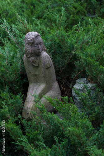 Statue of a woman sitting in the bushes. Muzeon Art Park in Moscow photo