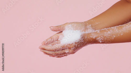 Skin care routine concept: gently exfoliating arm for healthy radiance on pastel pink background photo