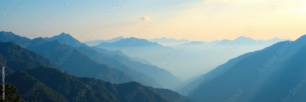 Obraz premium Misty morning over a vast mountain range under clear blue sky, dawn, mountain range, mist