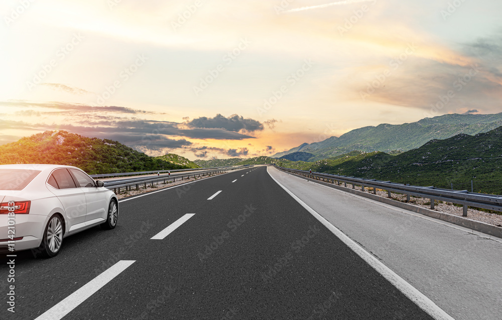 The car is driving along the highway surrounded by picturesque nature.