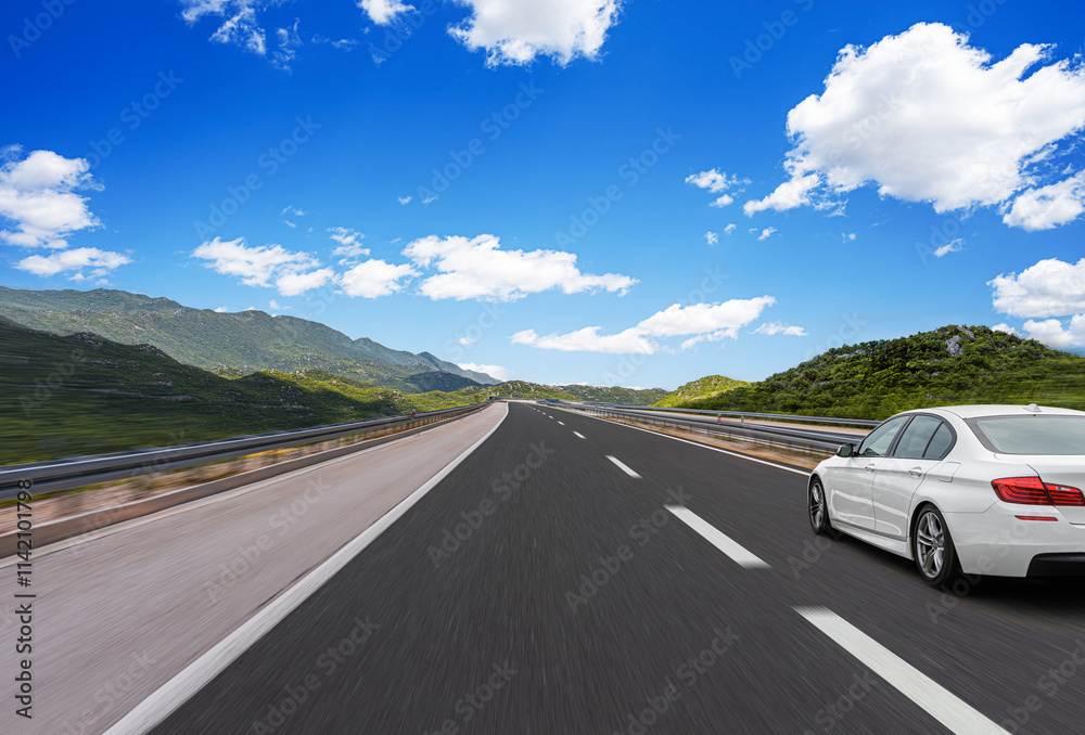 The car is driving along the highway surrounded by picturesque nature.