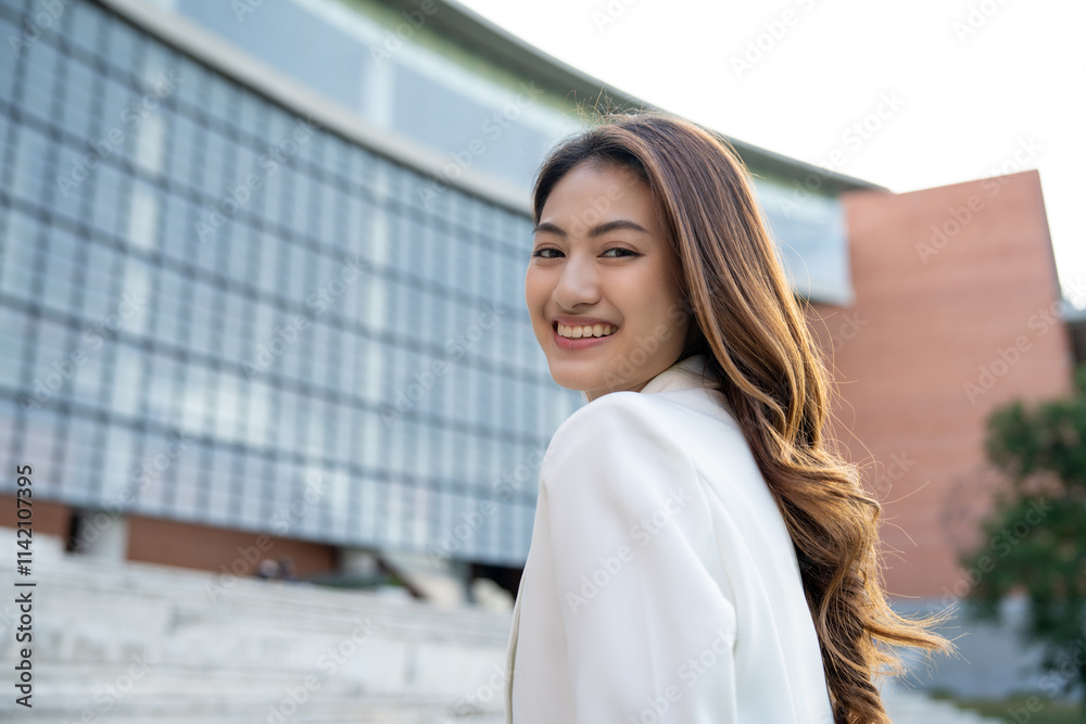 Fototapeta premium Portrait beautiful Businesswoman in suit standing at the buildings downtown. Confident woman looking towards their goals for success. Executive Smart businessman