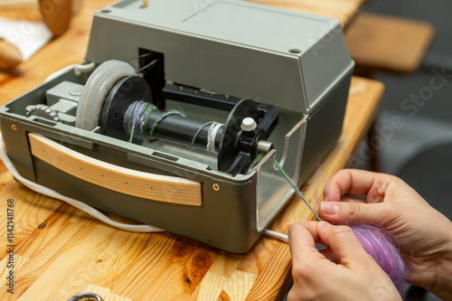 Distaff Day Vintage yarn winder in use with close-up of hands crafting colored threads