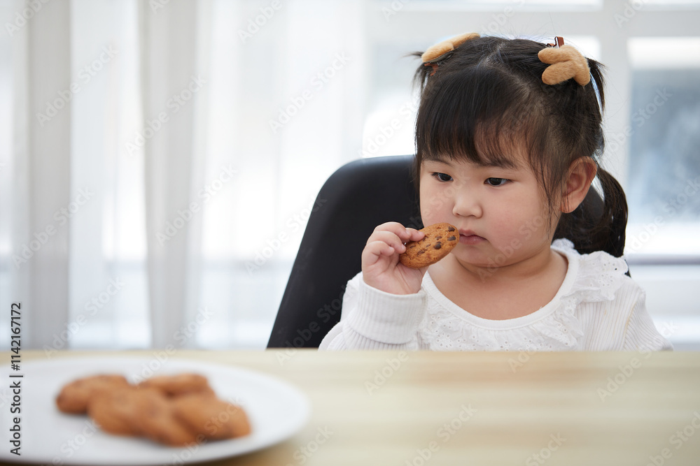 portrait child girl enjoy eating cookies in the kitchen portrait child girl enjoy eating cookies in the kitchen