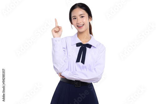 Happy pretty Asian student girl in school uniform pointing finger up isolated on white background.