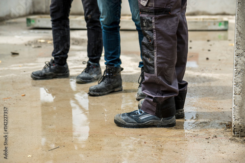 Construction workers in safety clothes standing on construction site.