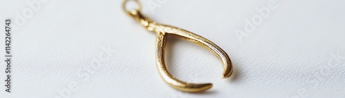Gold wishbone pendant on a white isolated background.