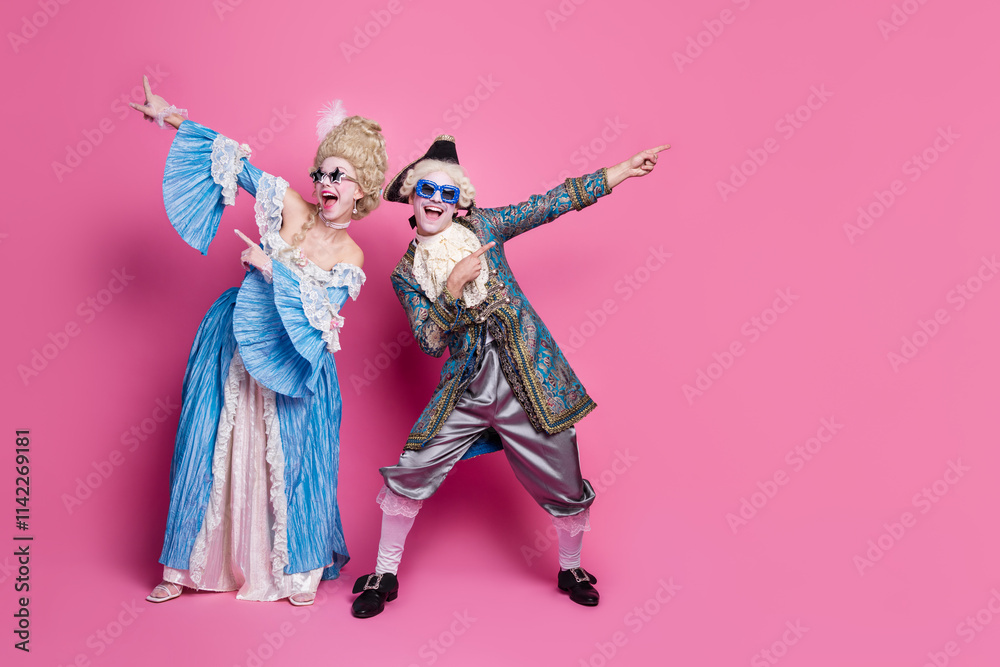Joyful couple in elaborate period costumes posing against a vibrant pink background. Embracing historical elegance at a lively theme party Joyful couple in elaborate period costumes posing against a vibrant pink background. Embracing historical elegance at a lively theme party