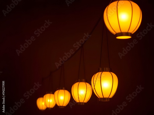 Warm Glow: A string of glowing lanterns illuminates a darkened space, casting a warm, inviting glow. The lanterns, with their soft, diffused light, create a cozy and atmospheric ambiance. photo