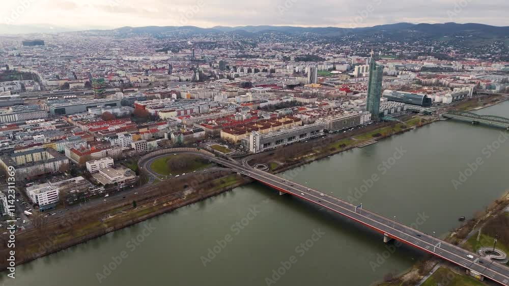 Cinematic Aerial View of Vienna: Danube River, Iconic Bridges, and Cityscape A stunning drone shot capturing Vienna's Danube River, its iconic bridges, and the city's scenic skyline from above. 