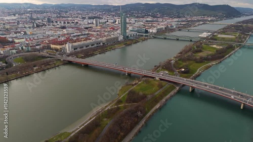 Cinematic Aerial View of Vienna: Danube River, Iconic Bridges, and Cityscape A stunning drone shot capturing Vienna's Danube River, its iconic bridges, and the city's scenic skyline from above. 