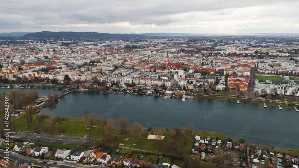 Cinematic Aerial View of Vienna: Danube River, Iconic Bridges, and Cityscape A stunning drone shot capturing Vienna's Danube River, its iconic bridges, and the city's scenic skyline from above. Cinematic Aerial View of Vienna: Danube River, Iconic Bridges, and Cityscape A stunning drone shot capturing Vienna's Danube River, its iconic bridges, and the city's scenic skyline from above.