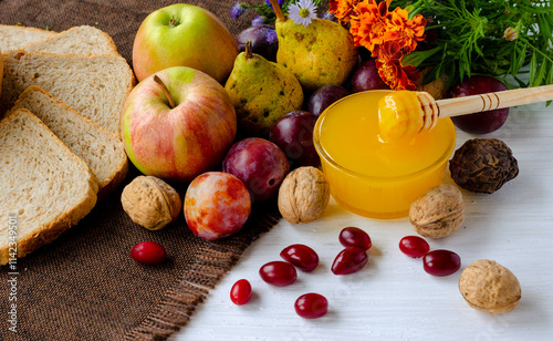 Fresh January apples and honey with seasonal berries, nuts on a rustic table. Autumn harvest.