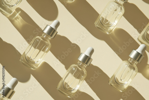 Glass vials with dropper lid in sunlight on beige background. Diagonal flat lay of unmarked containers with cosmetic serum with hard shadows. Close-up, vertical image