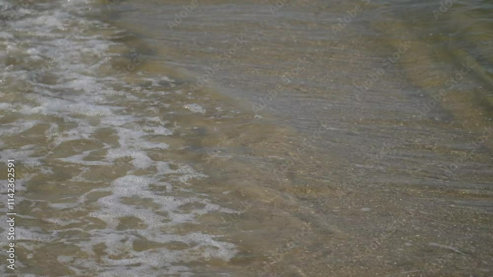 waves crashing over sand on beach