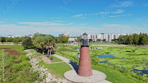 small brick lighthouse at Kissimmee Lakefront Park overlooking Lake Tohopekaliga with downtown Kissimmee in the background photo
