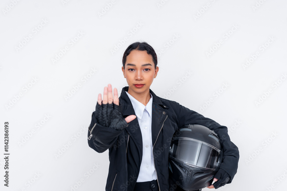 Motorcyclist Holding a Helmet While Gesturing Stop in a Studio Setting Motorcyclist Holding a Helmet While Gesturing Stop in a Studio Setting