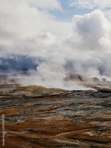 Steaming geothermal landscape under dramatic cloudy skies in Iceland