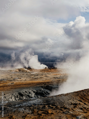 Steaming geothermal landscape under dramatic cloudy skies in Iceland
