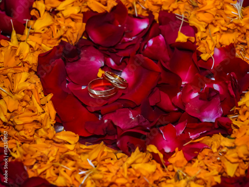 Wedding rings are placed on flower petals. 