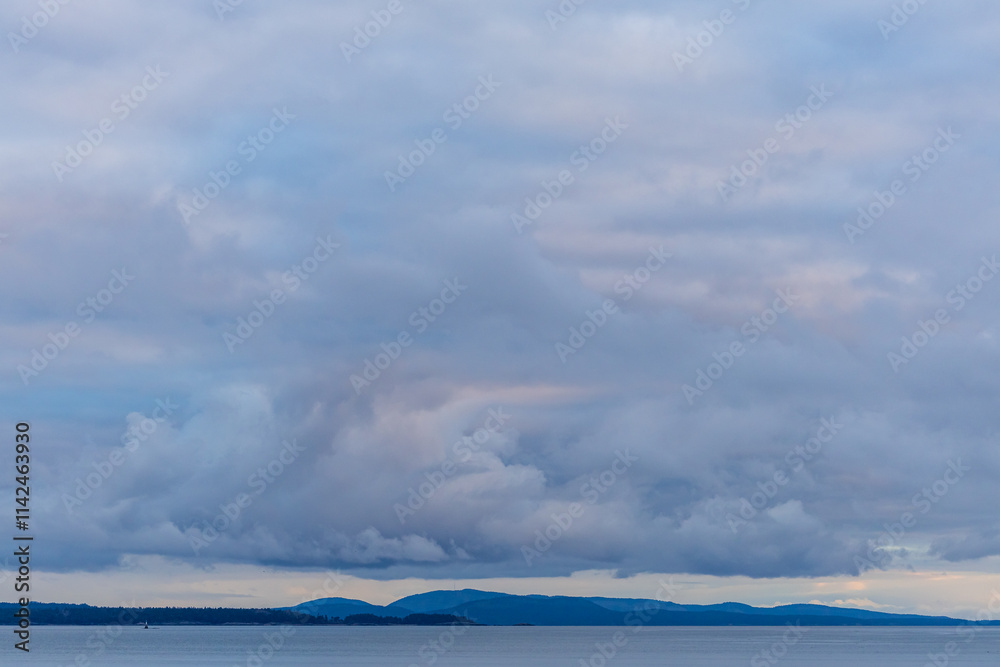 Overcast Sky Above Coastal Landscape With Distant Hills and Calm Water Overcast Sky Above Coastal Landscape With Distant Hills and Calm Water