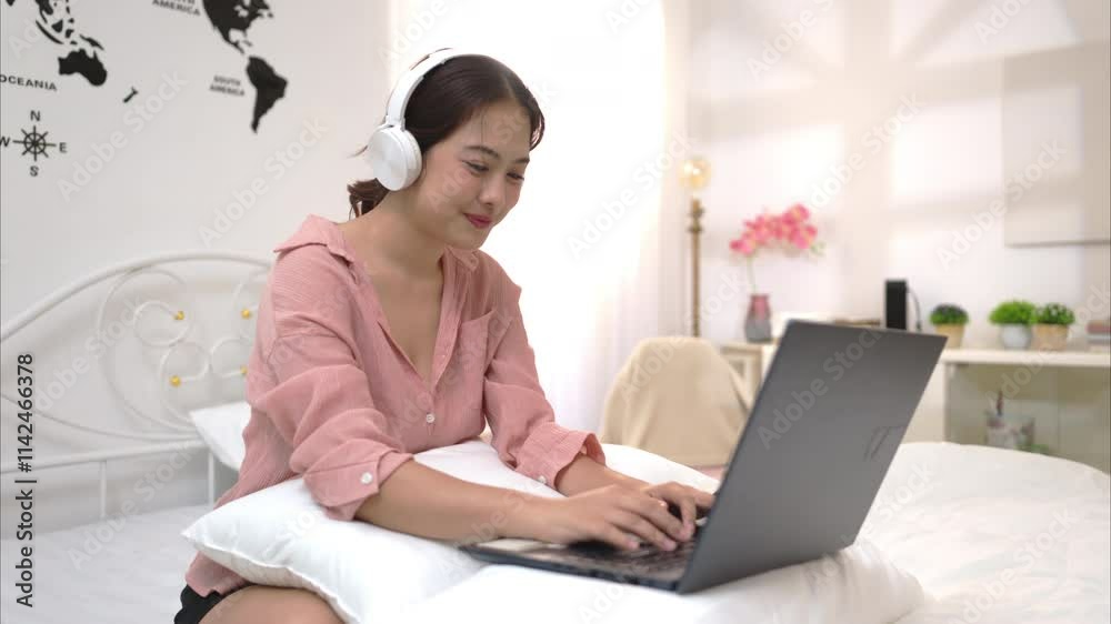 Asian young woman relaxing before bedtime on the bed in the bedroom