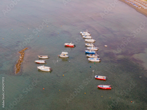 Boats moored near shore and breakwater, aerial view. photo