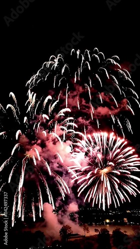 Stunning Display of Vibrant Fireworks Over a City Skyline Illuminating the Night Sky with Brilliant Colors and Dynamic Patterns Creating a Festive Atmosphere