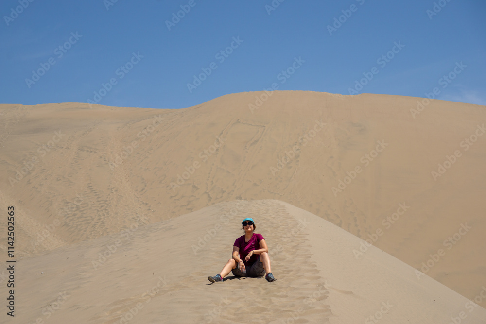Sporty woman enjoying outdoor in the breathtaking Ica desert by the iconic Huacachina Oasis Peru Sporty woman enjoying outdoor in the breathtaking Ica desert by the iconic Huacachina Oasis Peru