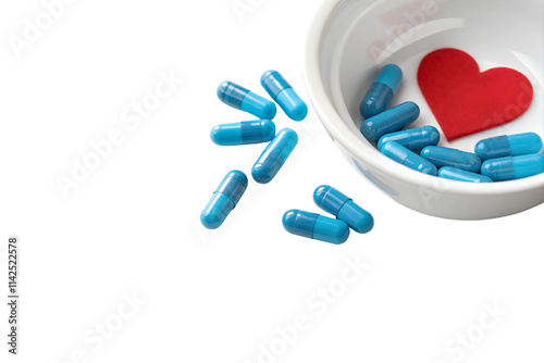 Blue Capsules in White Bowl with Red Heart on White Background with Copy Space photo