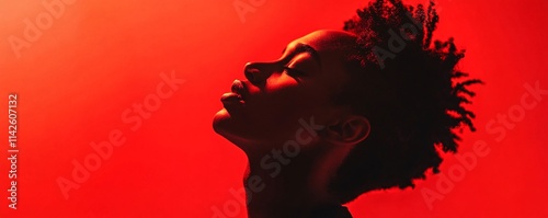 Young model posing with red backlight showing her beautiful face