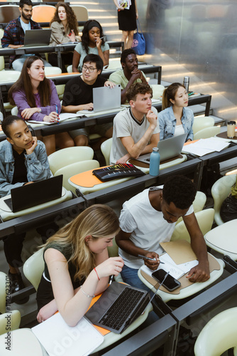 High angle view of multiracial male and female students sitting in lecture hall at university