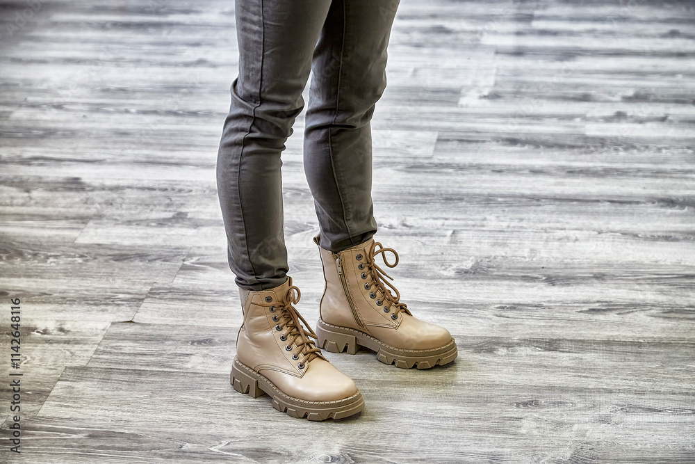 Trendy model showcases stylish boots while posing in a chic indoor setting Trendy model showcases stylish boots while posing in a chic indoor setting