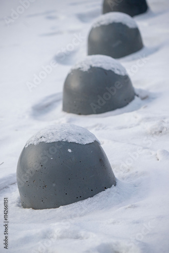 Four large grey rocks covered in snow photo