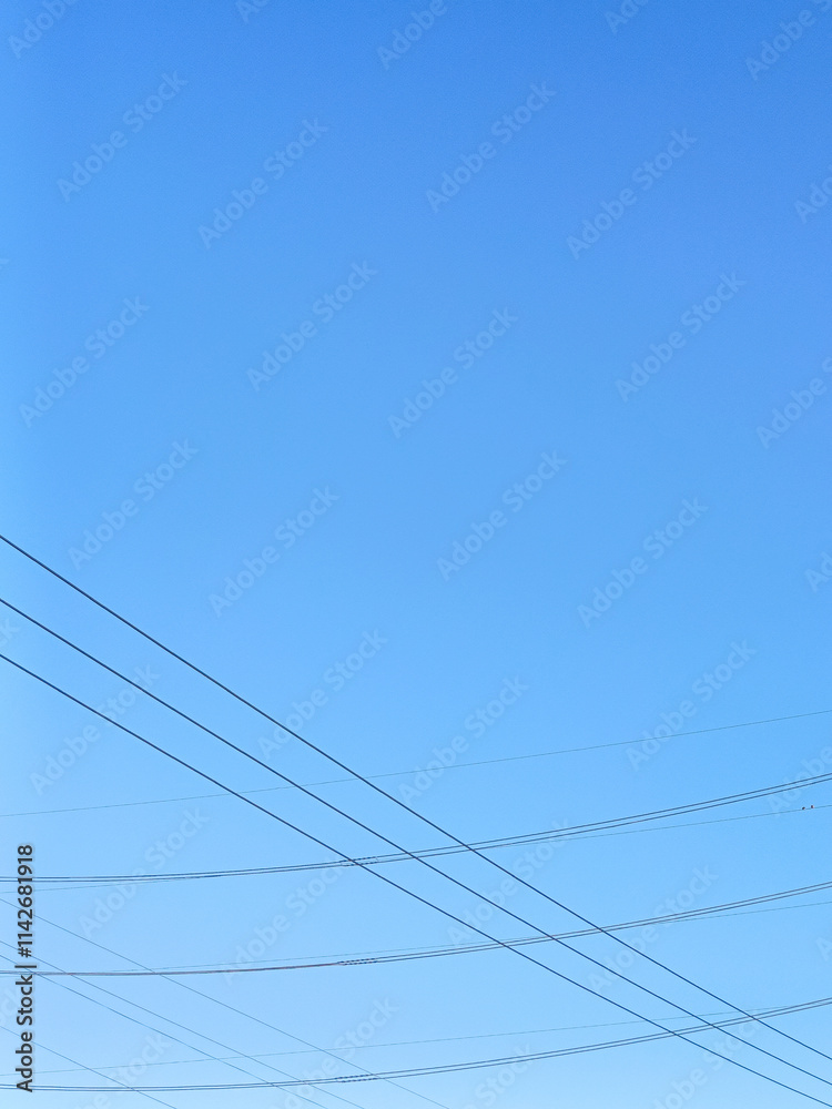 Fototapeta premium Minimalistic photography of a clear sky, beautiful weather, and beautiful interspersed high-voltage power lines.